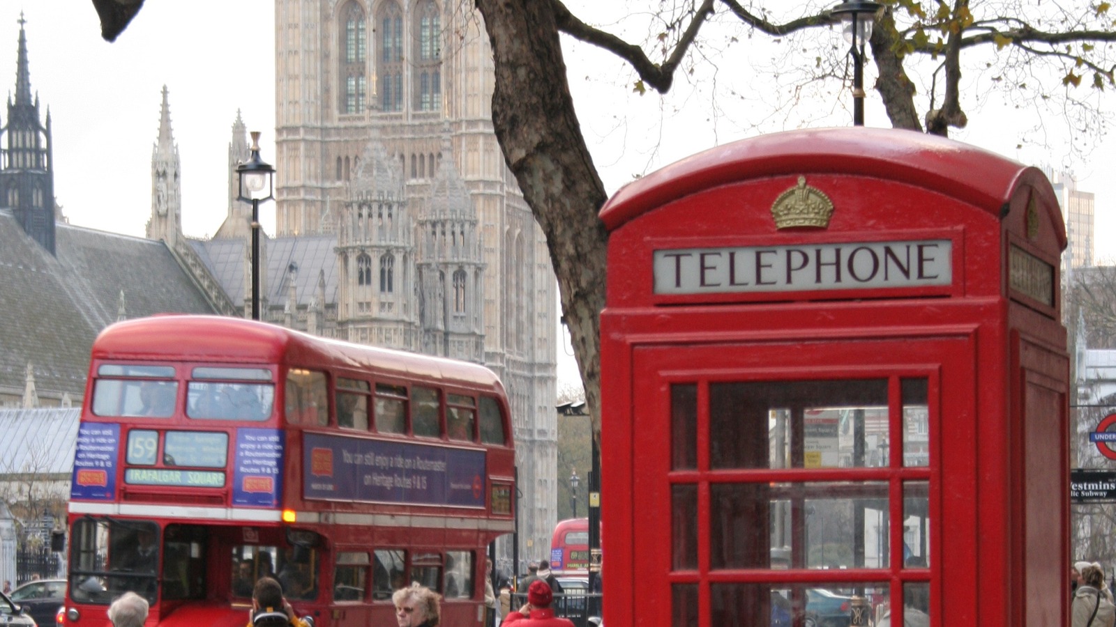 Red Routemaster bus and telephone box on a London street with the Palace of Westminster behind