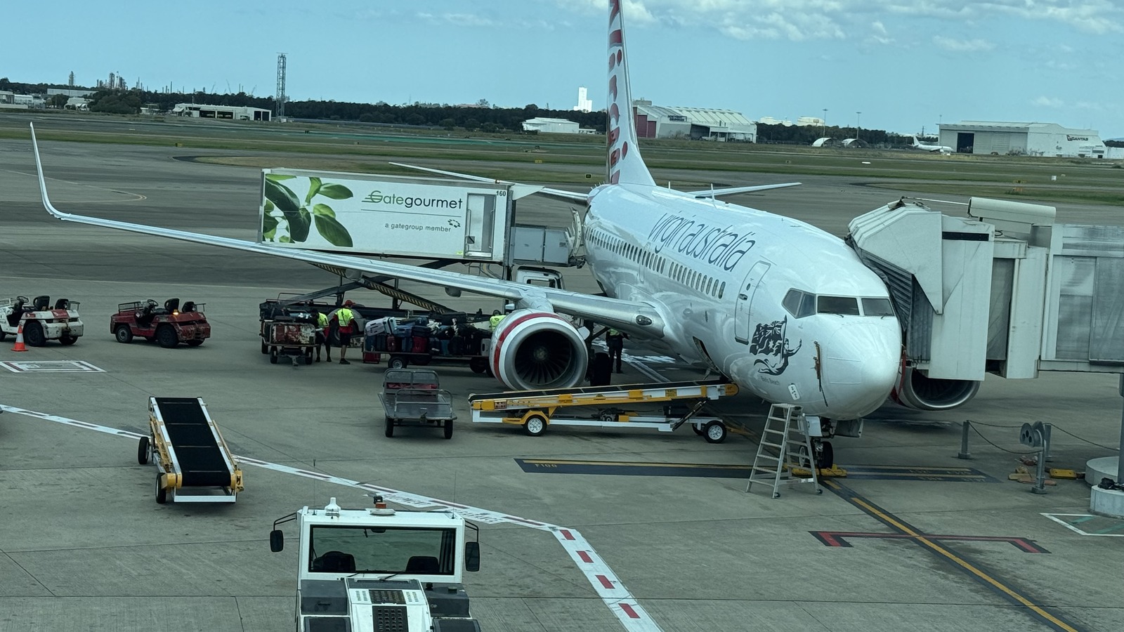 Virgin Australia Boeing 737 aircraft parked at an airport gate in daylight