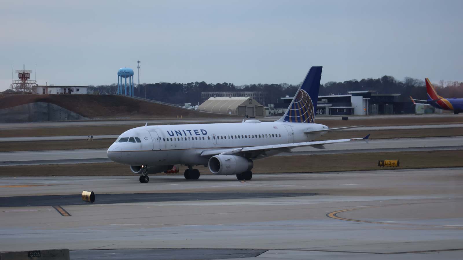 A United Airlines jet taxis at Hartsfield-Jackson Atlanta International Airport on a gray December evening.
