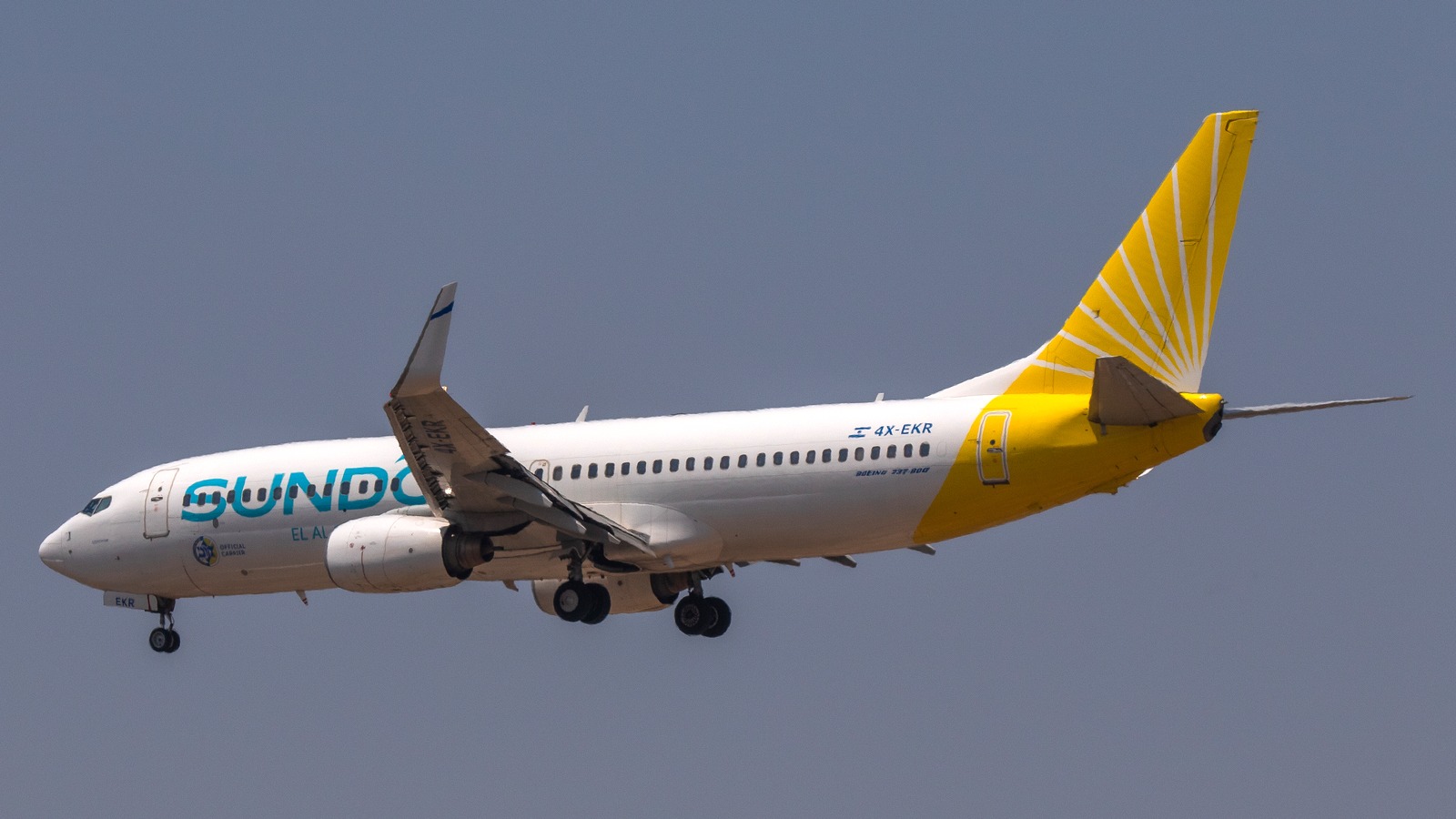 Sun d'Or Boeing 737-800 with yellow tail climbing after takeoff with registration 4X-EKR visible
