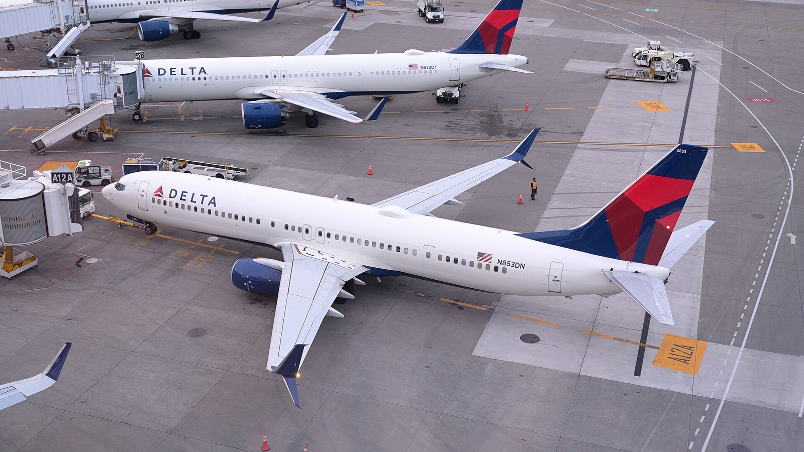 Two Delta Air Lines jets parked at adjacent gates at Seattle-Tacoma International Airport, seen from above