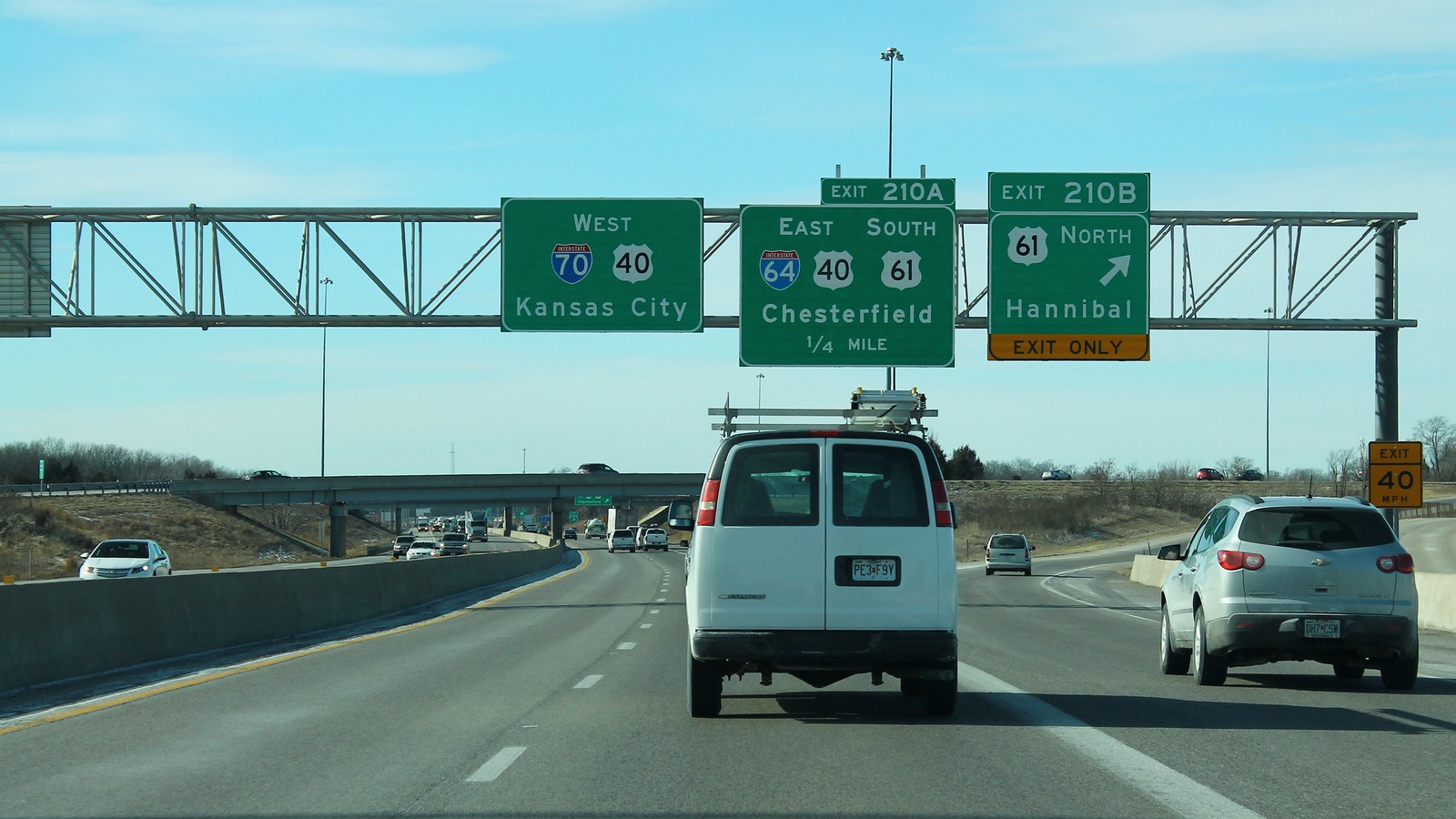 Westbound Interstate 70 approaching the I-64, U.S. 40, and U.S. 61 interchange near Wentzville, Missouri, with overhead signs for Exit 210A and Exit 210B.
