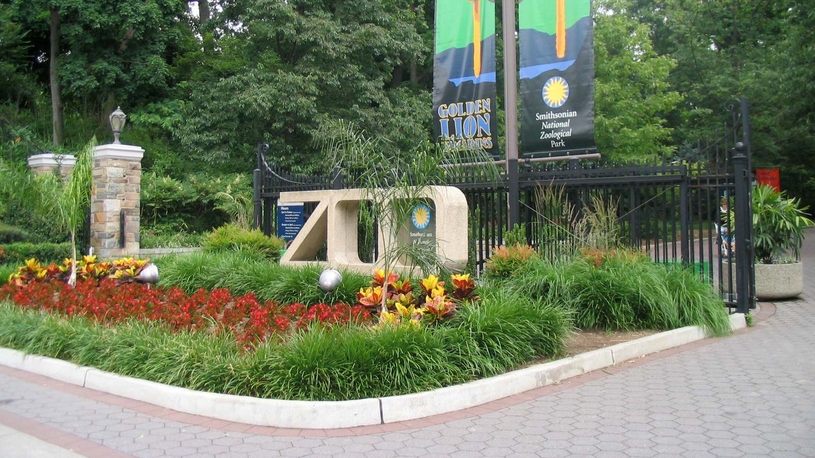 Front entrance of the Smithsonian's National Zoo in Washington with its ZOO sign, flower beds and banners