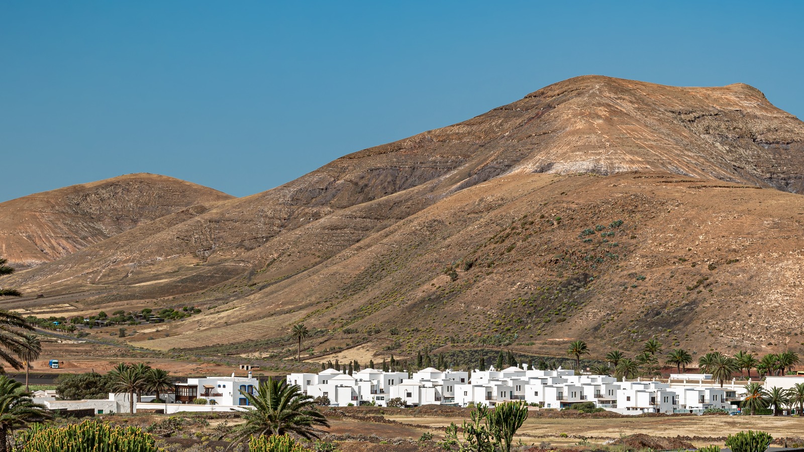 White houses of Yaiza with volcanic mountains behind under a clear sky