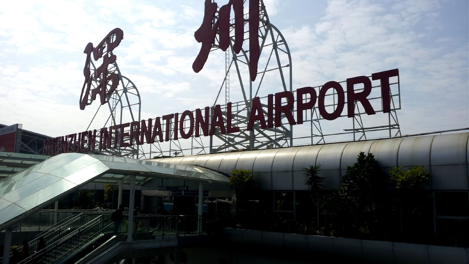 Entrance canopy and Shenzhen International Airport sign at Shenzhen Bao'an International Airport, with the Chinese characters for Shenzhen on the roof.