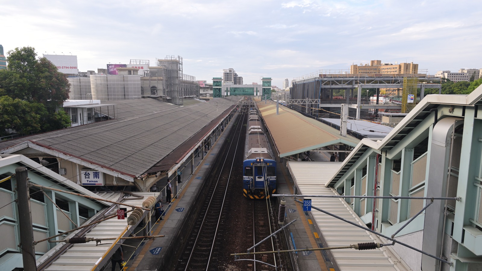 Taiwan Railway train at the surface platforms of Tainan Station seen from an overpass, with the Tainan station name visible on the left