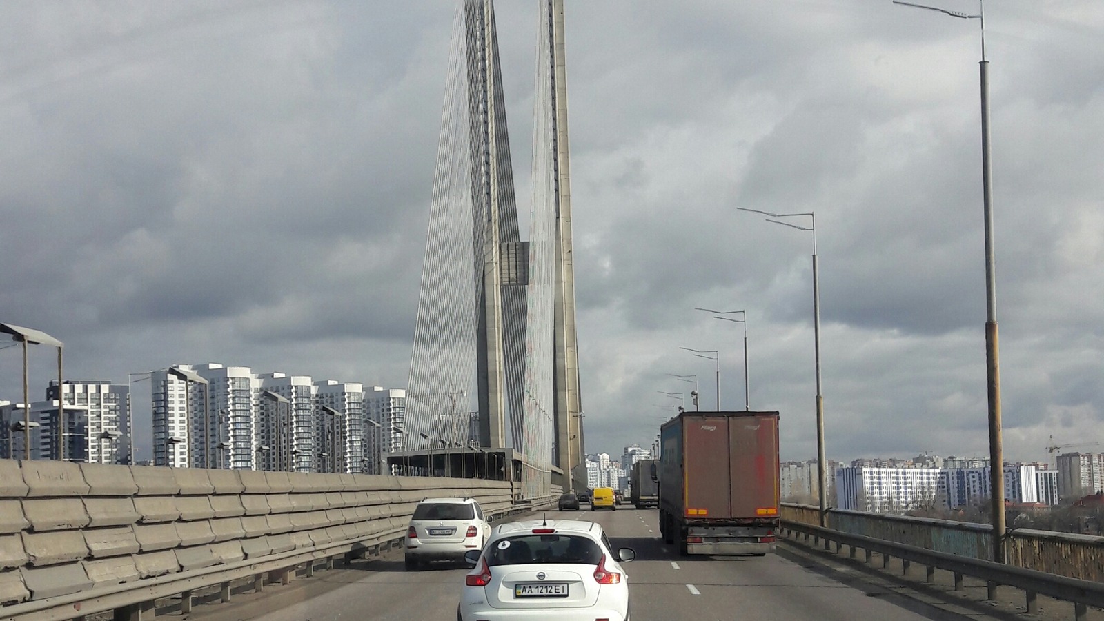 Vehicles on the Kyiv Southern Bridge roadway approaching the cable-stayed pylon over the Dnipro
