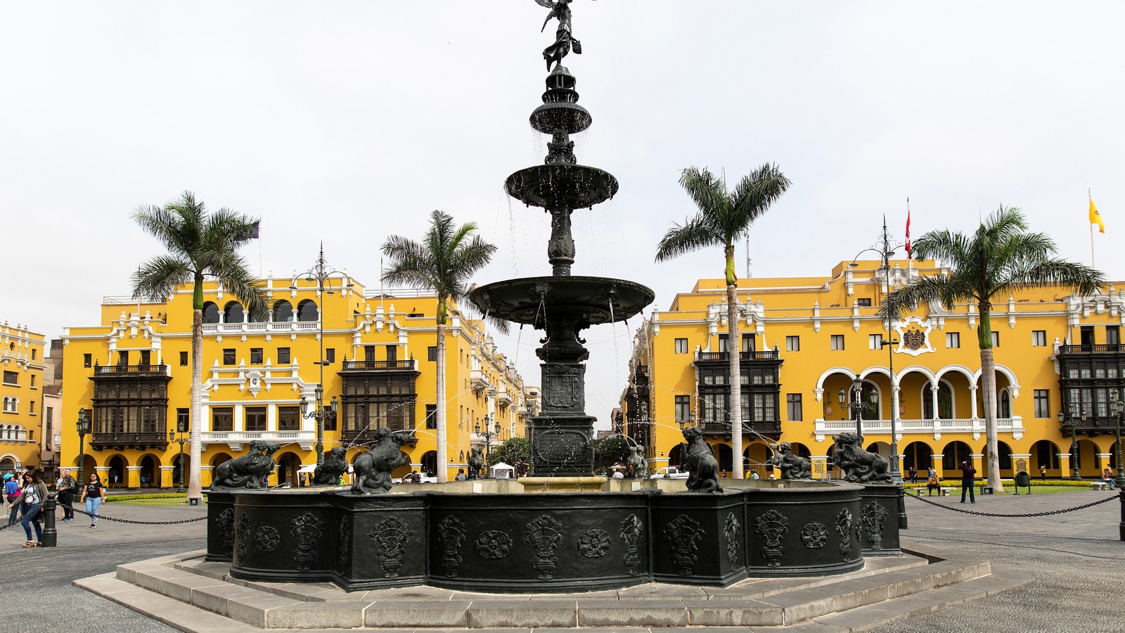 Fountain and yellow colonial buildings on the Plaza Mayor in central Lima, Peru, by day