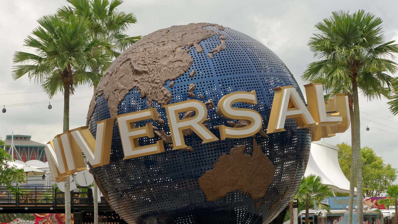 The Universal globe at the entrance to Universal Studios Singapore on Sentosa island, framed by palm trees