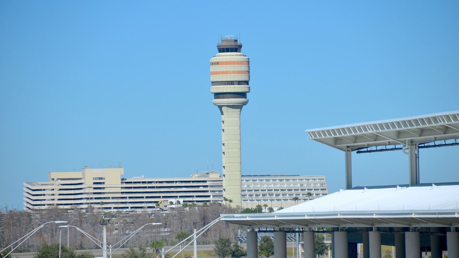 Air traffic control tower and Terminal A and B buildings at Orlando International Airport in daylight