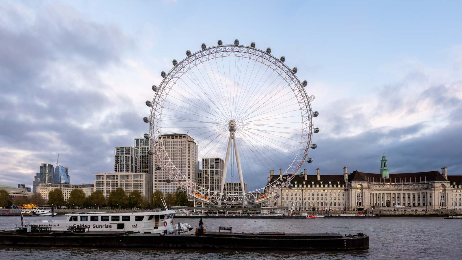 The London Eye on the South Bank of the Thames in London under a cloudy sky