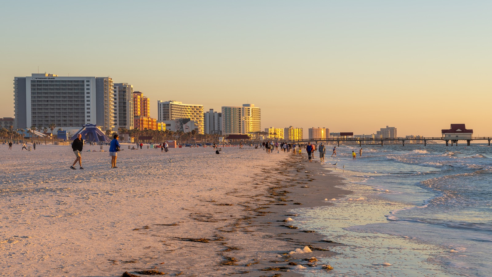 Visitors on Clearwater Beach in Florida beside the Gulf of Mexico at sunset
