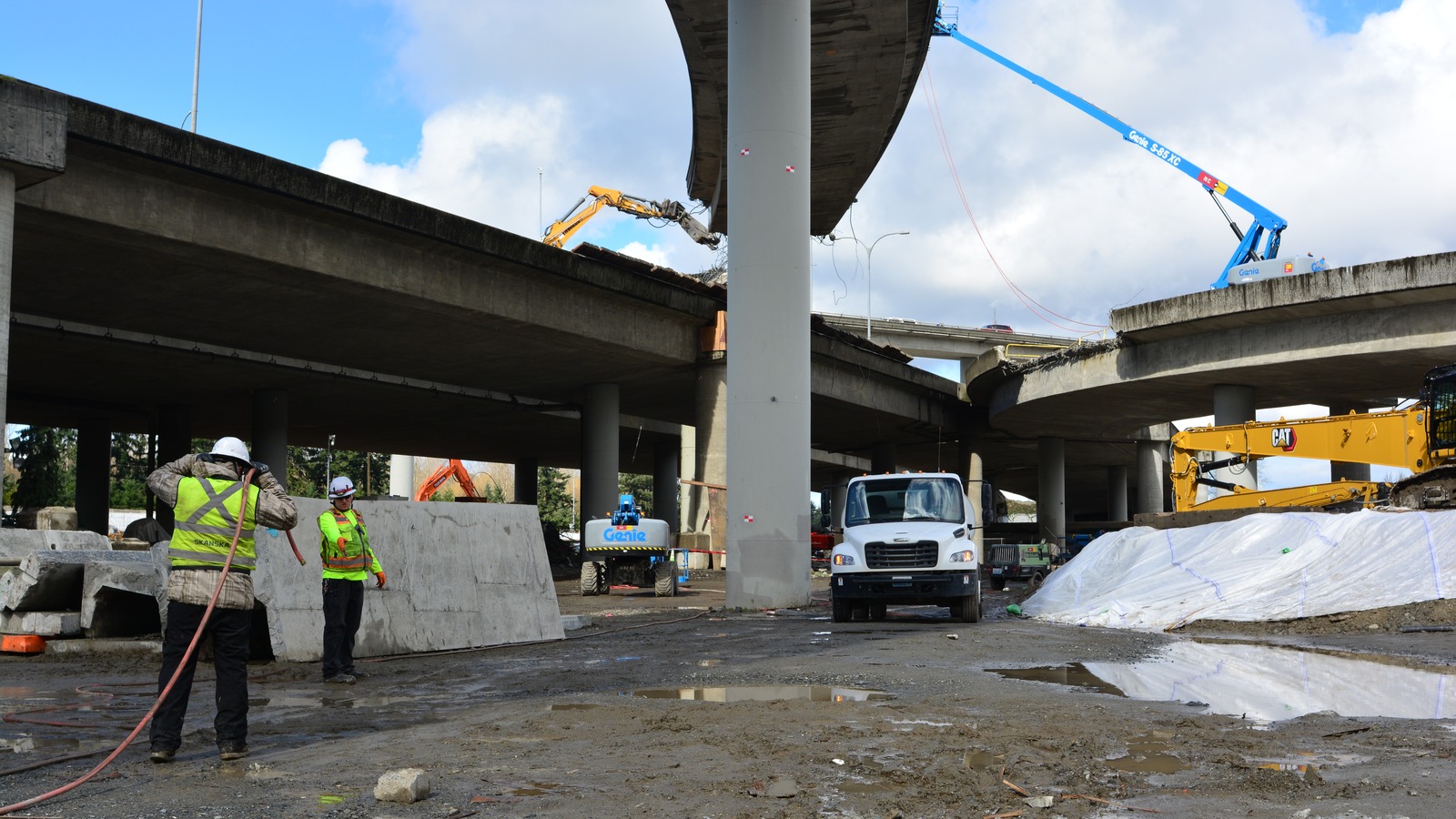 Construction crews and equipment under the I-405 and SR 522 interchange ramps in Bothell, Washington