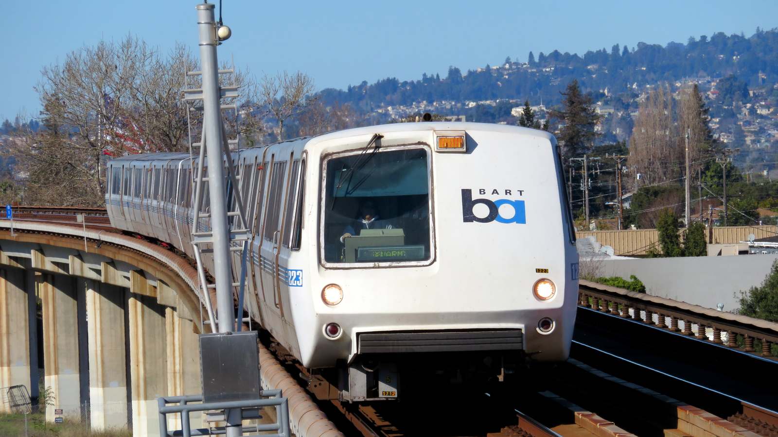 A BART train with an A car in the lead arriving on the elevated track at San Leandro station