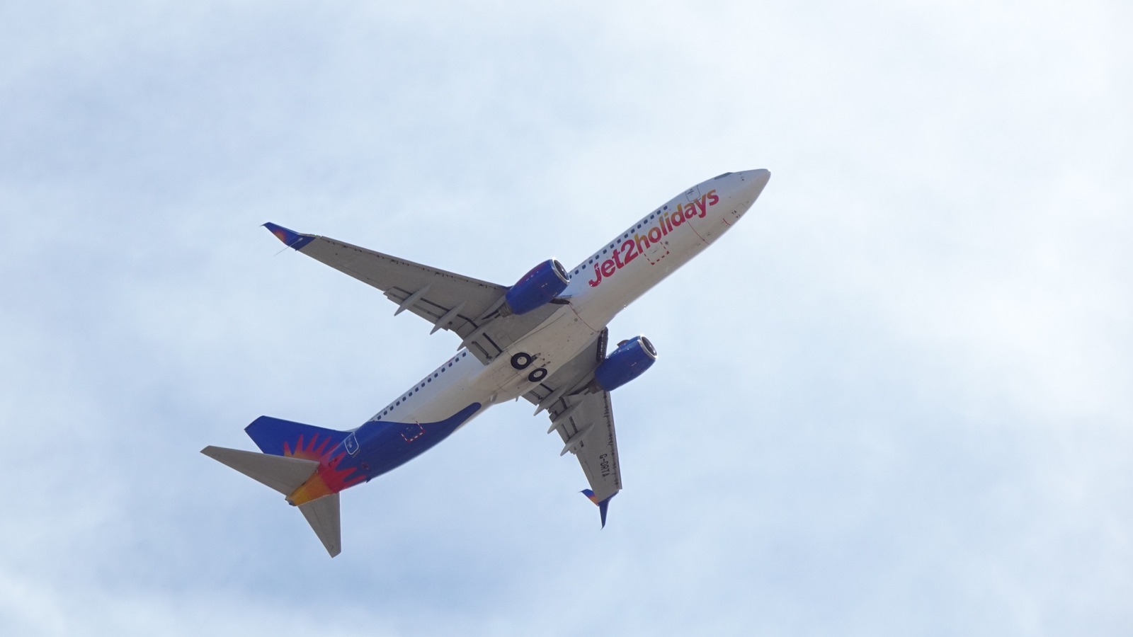 Jet2holidays Boeing 737 climbing after takeoff against a bright cloudy sky