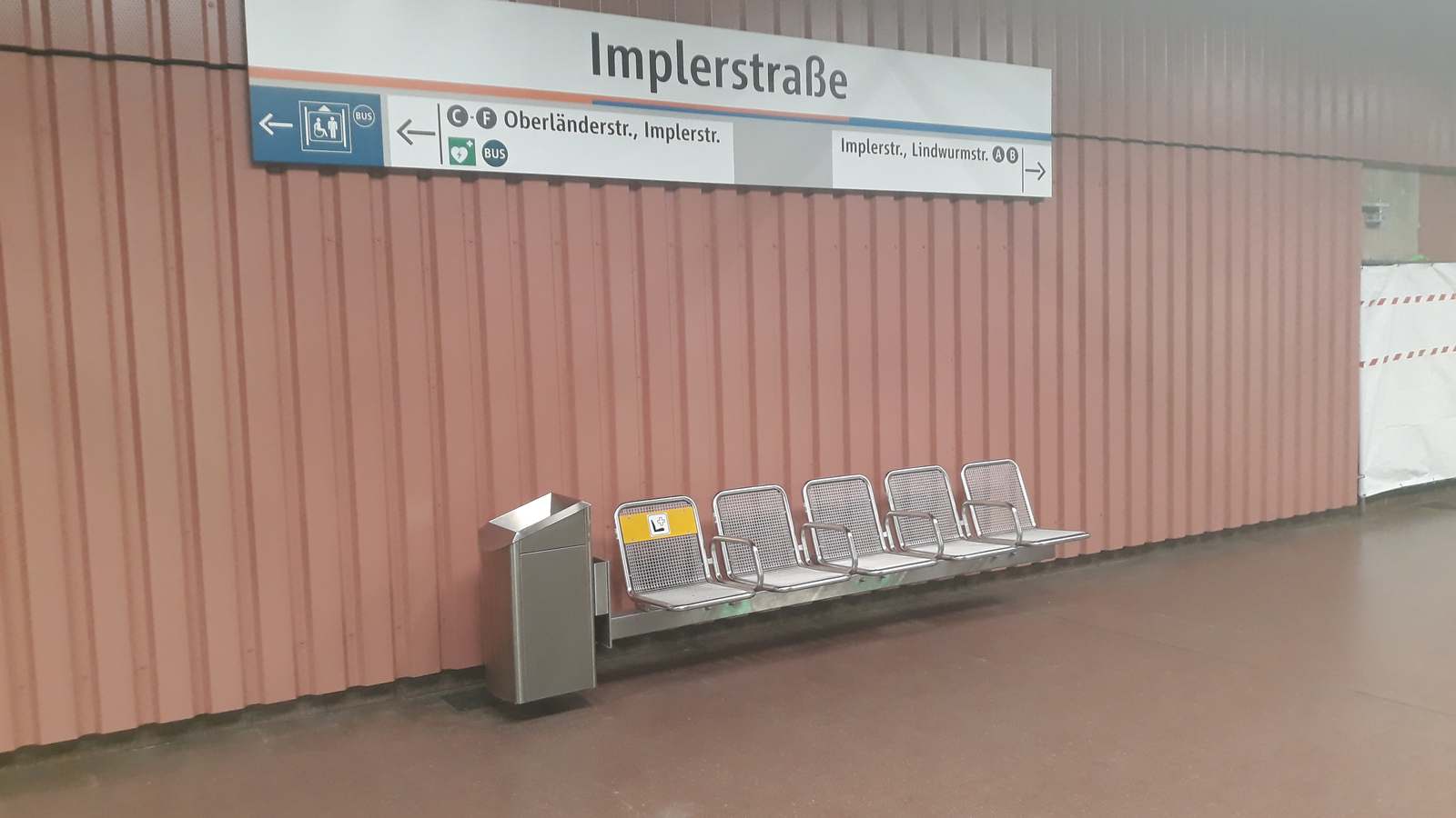 Implerstraße station name sign and a row of seats on the Munich U-Bahn platform