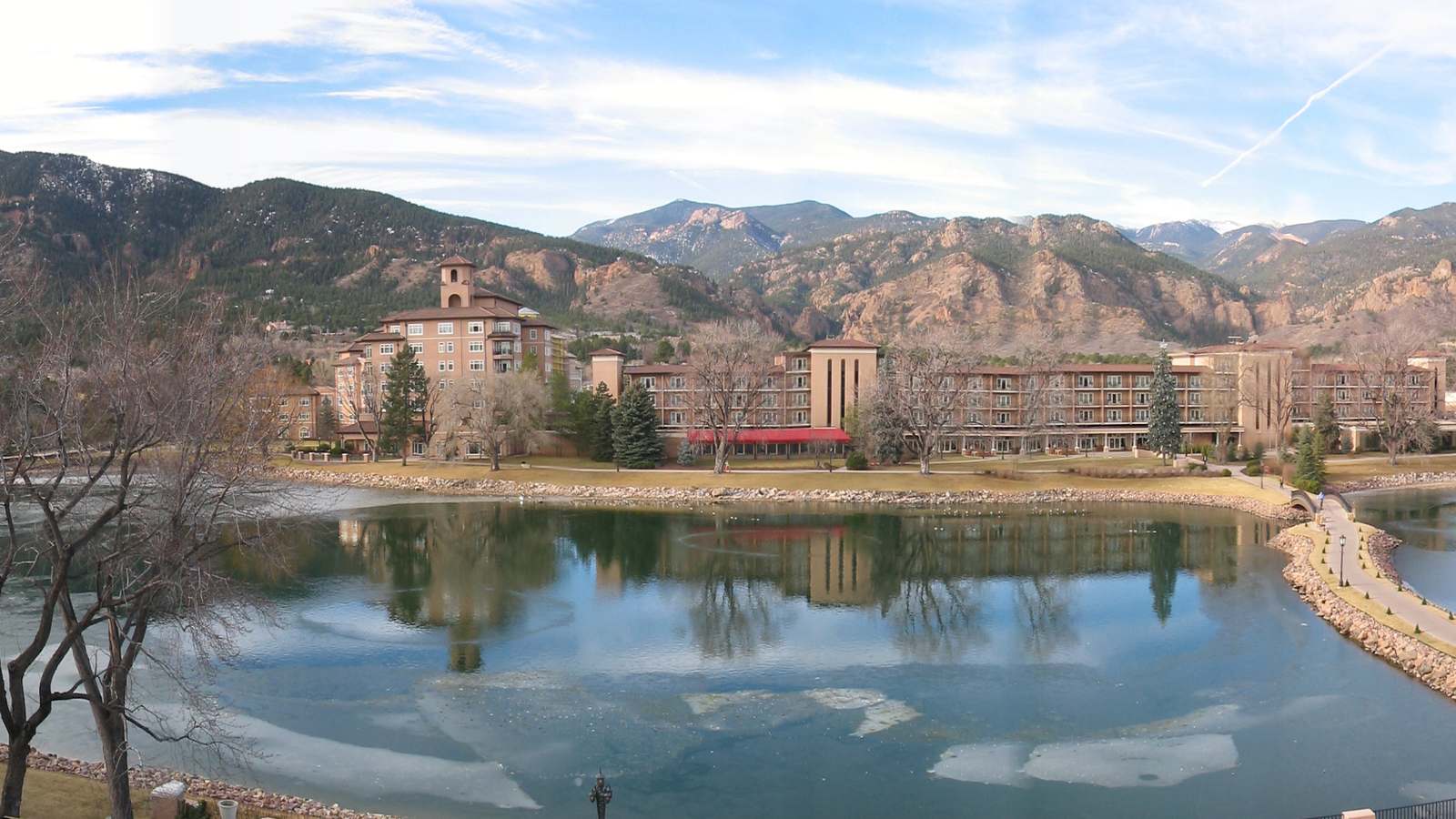 The Broadmoor resort's pink stucco buildings reflected in its lake below the Cheyenne Mountain foothills in Colorado Springs.