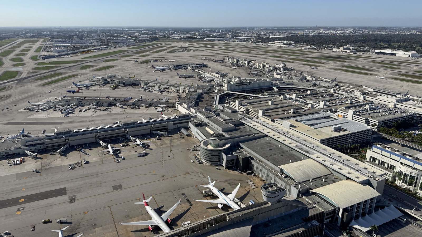 Aerial view of Miami International Airport terminals, apron, and runways on a clear day