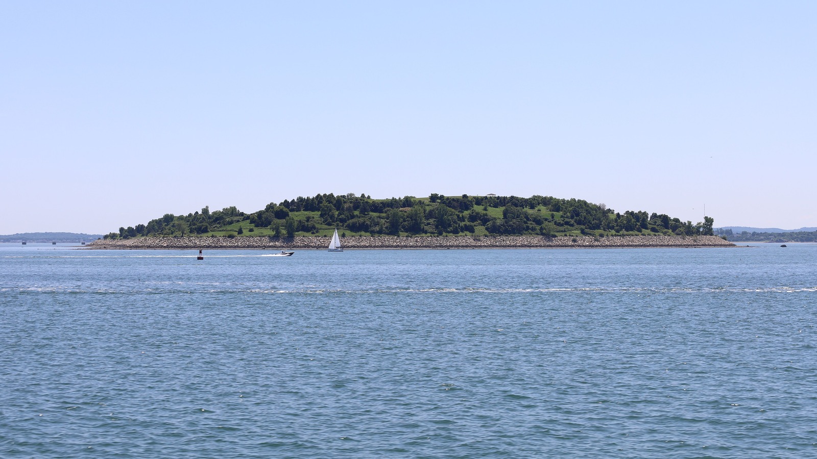 Spectacle Island in Boston Harbor seen across the water from a ferry on a clear day