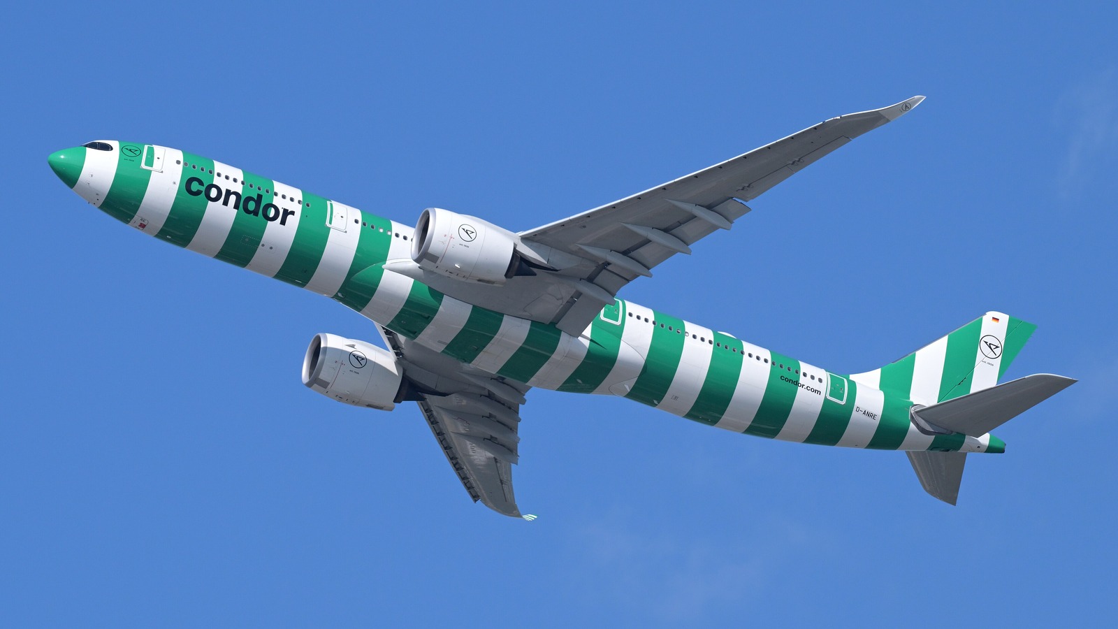 Condor Airbus A330-900 in green and white striped livery climbing against a blue sky