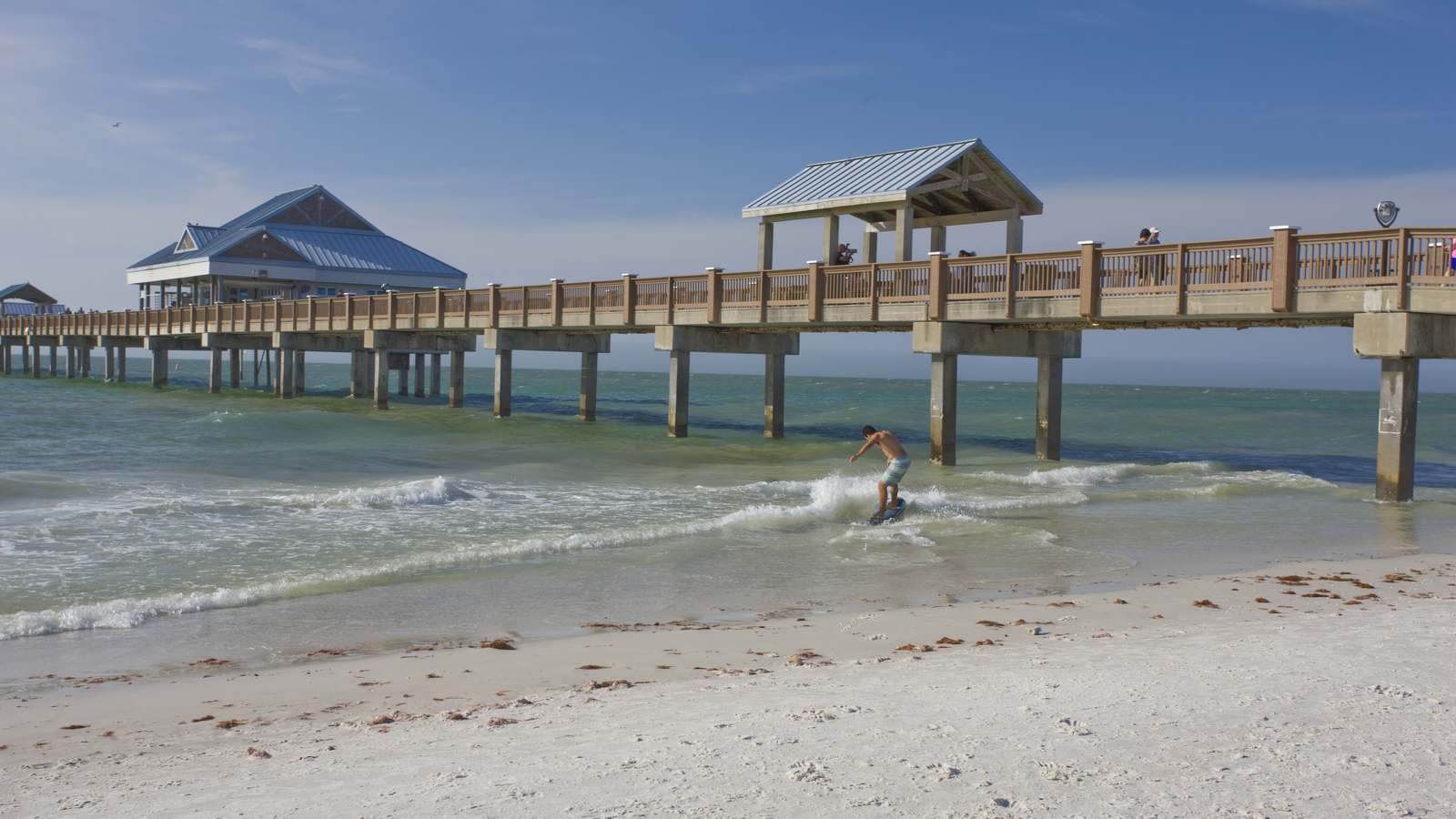 Clearwater Beach Pier 60 and white sand with a surfer in the Gulf of Mexico, Pinellas County, Florida
