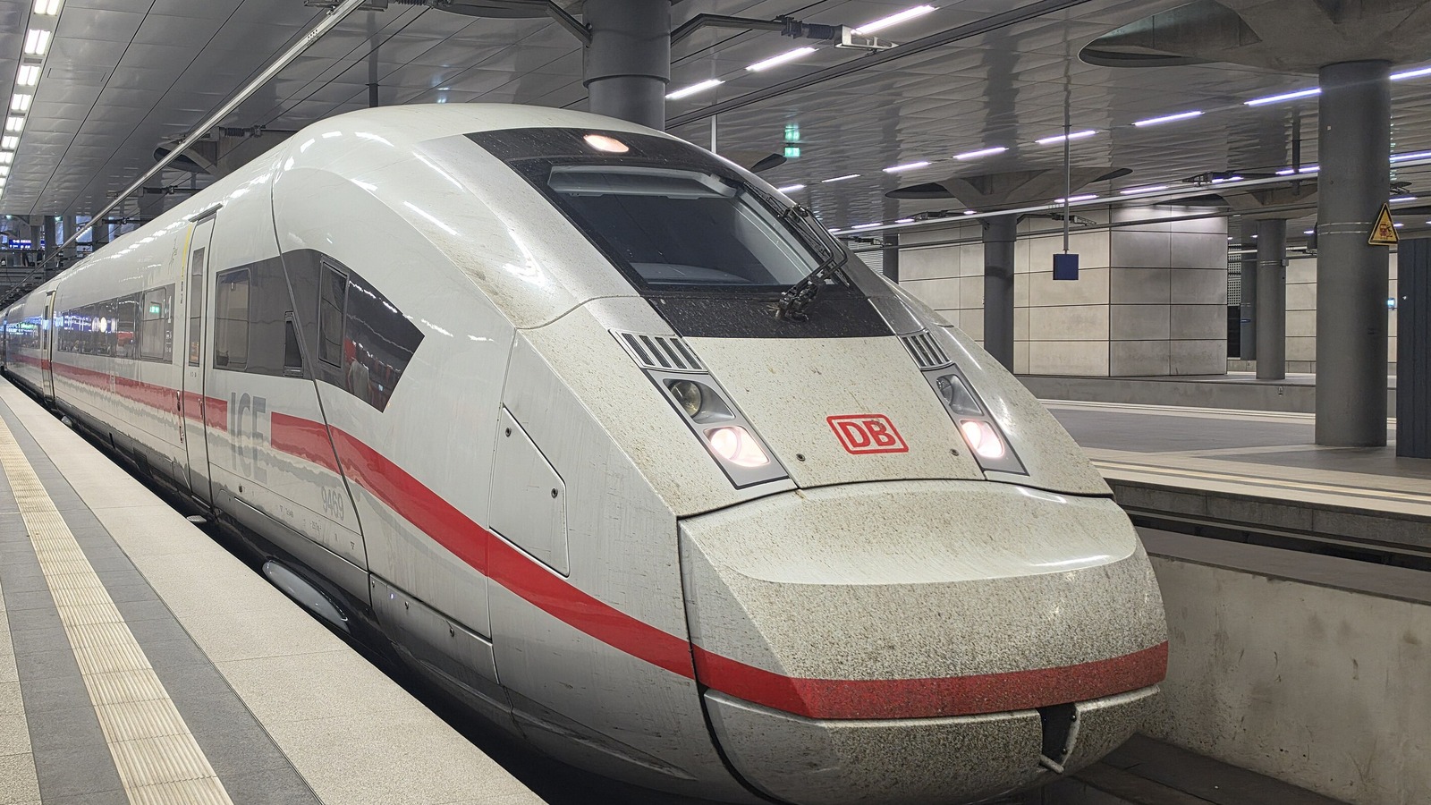 A Deutsche Bahn ICE 4 high-speed train with the DB logo standing at a platform in Berlin Hauptbahnhof