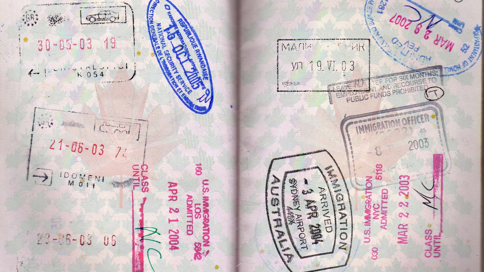 Open passport pages covered with entry stamps including U.S. immigration admission stamps