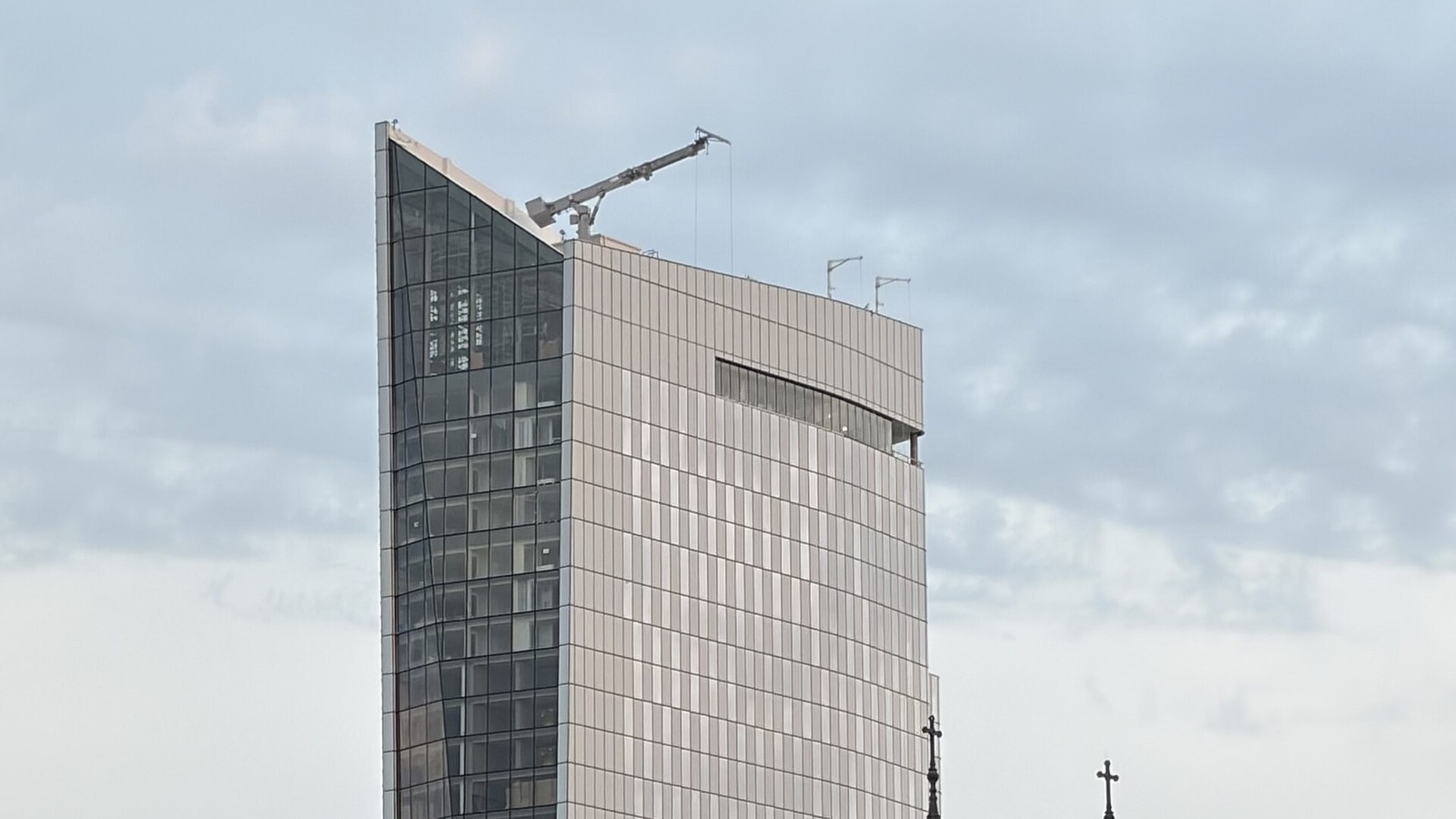 The Signia Hilton Indianapolis tower in August 2026 with a rooftop maintenance rig, as construction nears completion