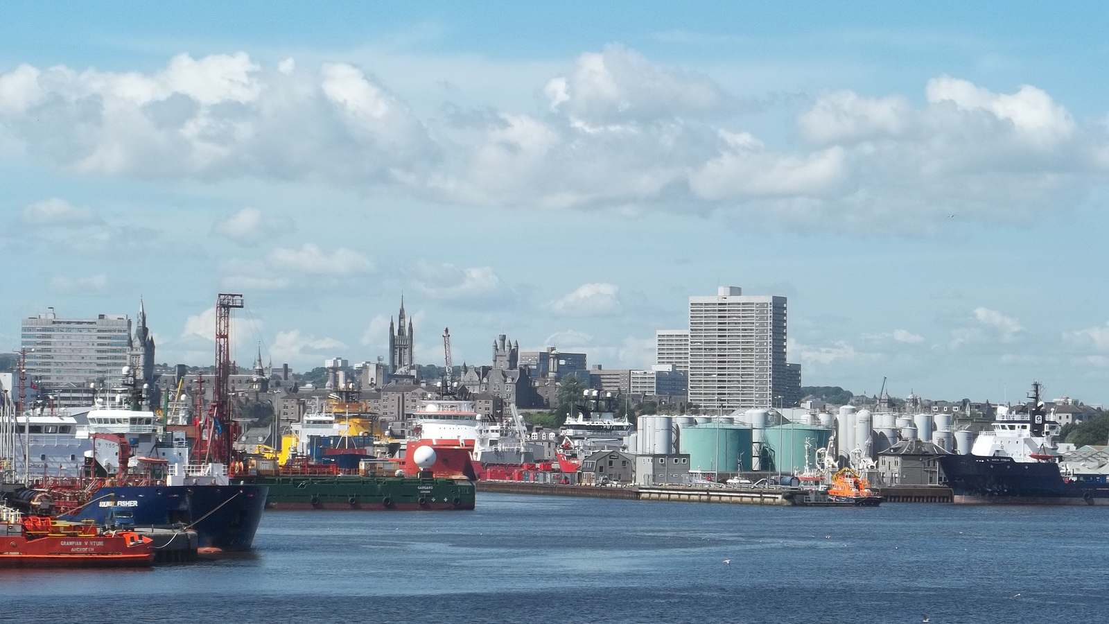 Aberdeen harbour with ships at the quays and the granite city skyline behind