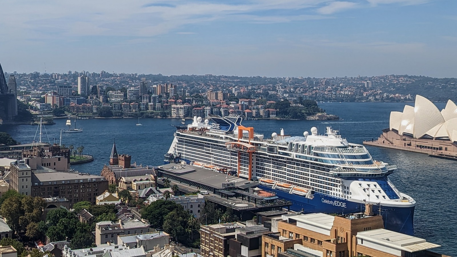 Celebrity Edge cruise ship docked at a passenger terminal in daylight