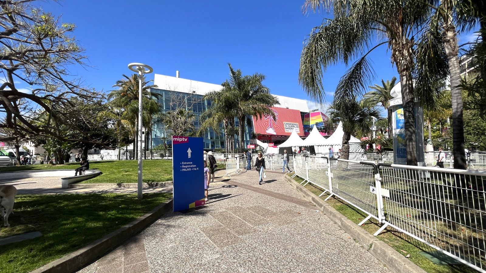 Palais des Festivals surroundings in Cannes during April 2023 event staging, with palms and pedestrian barriers.