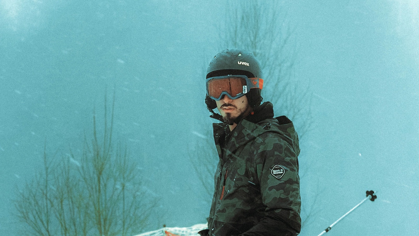 A skier wearing a helmet and ski goggles on a snowy slope.